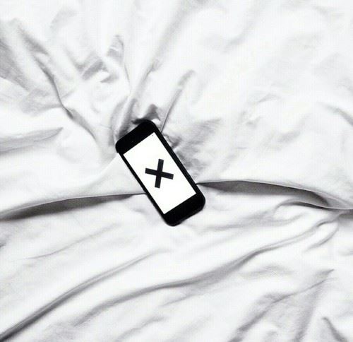 ベッドの上でのスマートフォン