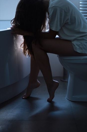 夜中トイレに座る女性