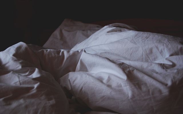 暗く乱れた不眠症の人のベッドルームの画像
