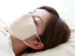 夜用マスクをつけて寝る女性の画像