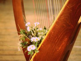 花が添えられた美しいハープ楽器の画像