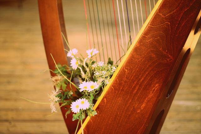 花が添えられた美しいハープ楽器の画像